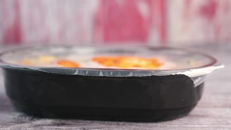 a sealed plastic food container on a wooden surface