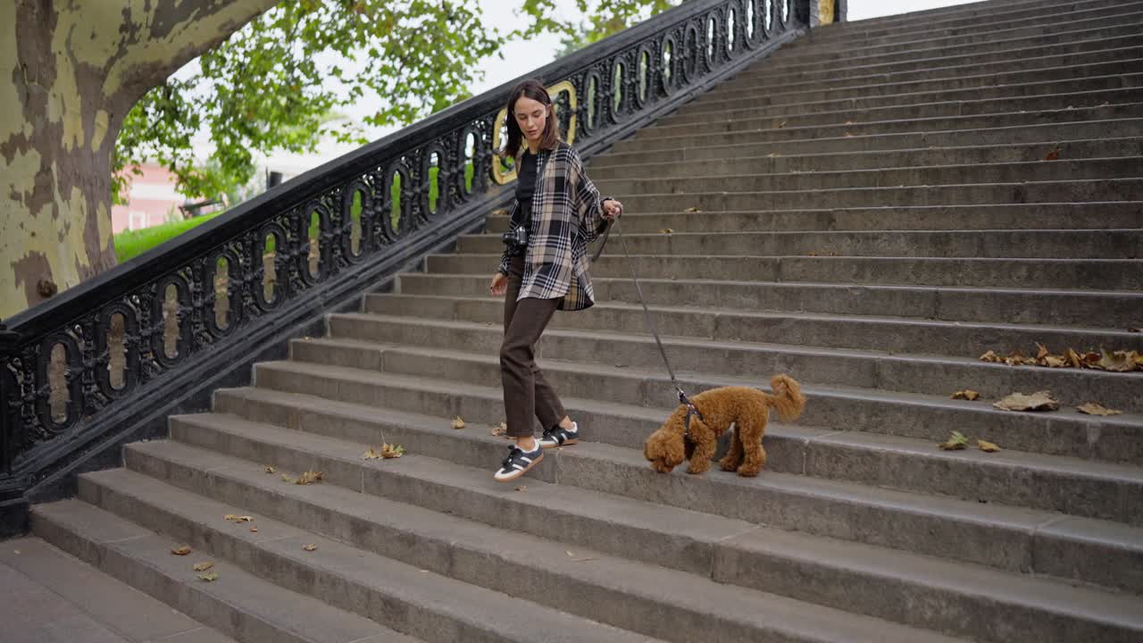 mujer caminando con su perro por un conjunto de escaleras