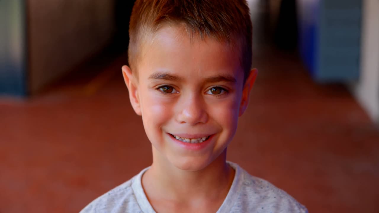 retrato de un niño de escuela lindo de pie en el corredor 4k