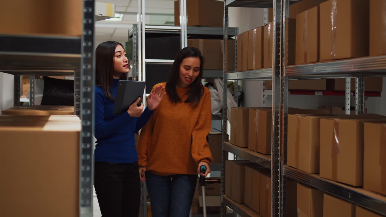 Two women using tablet in warehouse