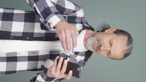 Vertical-video-of-Old-man-shopping-with-credit-card.