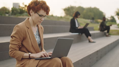 businesswoman using laptop in park