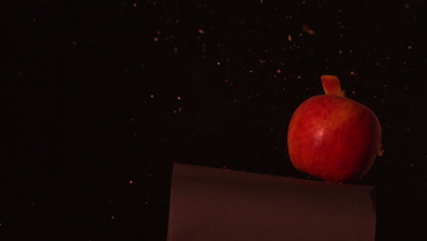 Arrow-shooting-through-red-apple-on-black-background