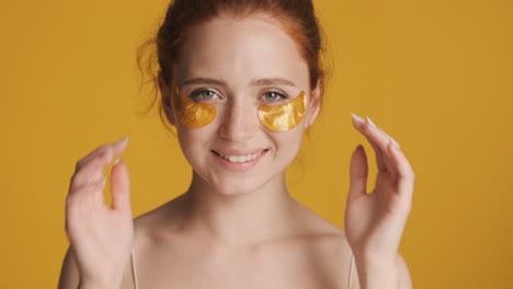 Redheaded-girl-in-front-of-camera-on-yellow-background.