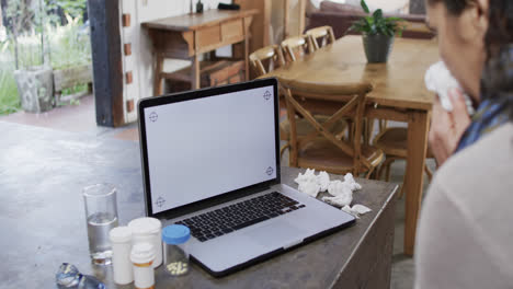 Biracial-Frau-Mit-Erkältung-Macht-Videoanrufe-Mit-Laptop-Mit-Kopierplatz-Zu-Hause,-Zeitlupe