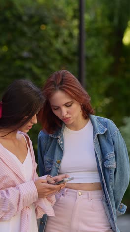 two women looking at a smartphone