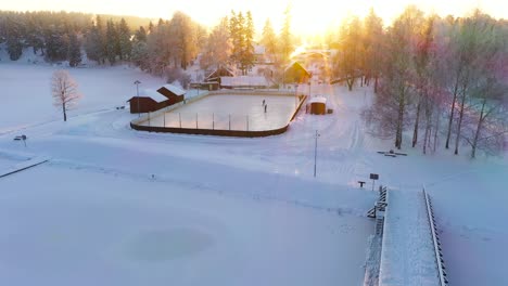 Gruppe-Von-Menschen,-Die-Auf-Gefrorenem-Eis-In-Ländlicher-Umgebung-Eislaufen-Und-Hockey-Spielen,-Drohnenaufnahme-Aus-Der-Luft