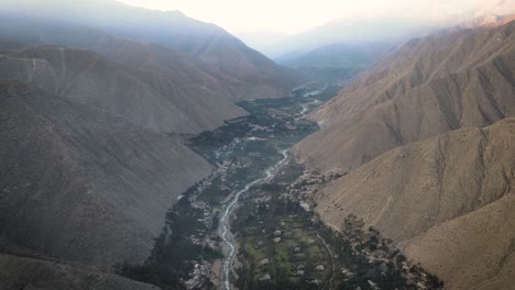 an overview of a green valley and a river with hills on the side in peru