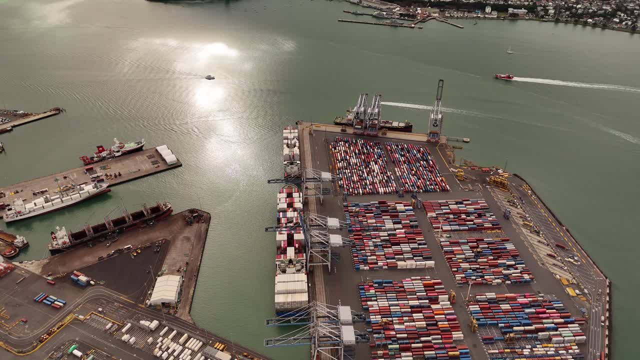 Port area of cargo shipping container and sun reflection on water. Aerial top down. Industrial harbor of Auckland city, New Zealand