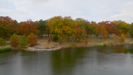 pull back over a pond and away from trees in the park in kirkwood in autumn on a pretty day