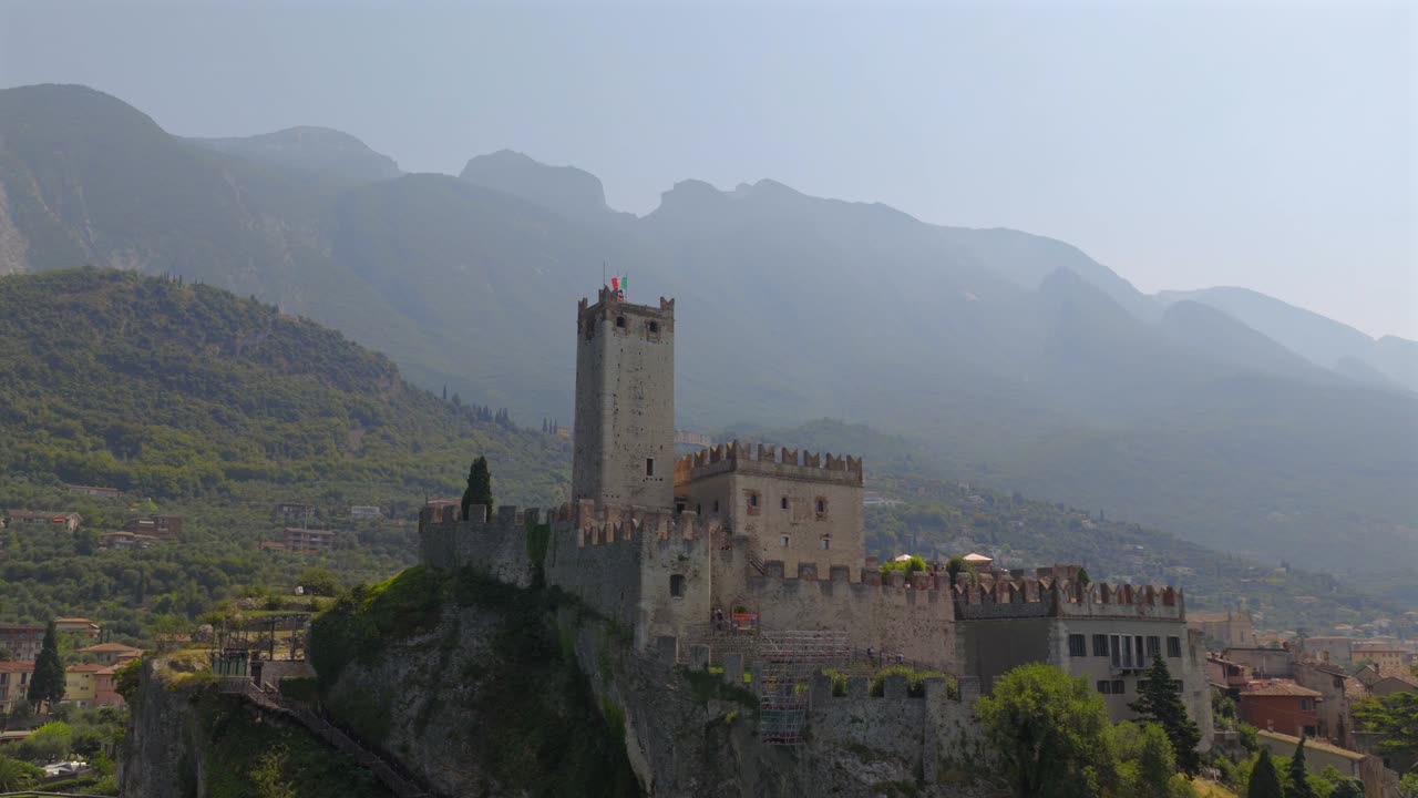 Filmato drone 4K del Castello di Malcesine (Castello Scaligero) sul Lago di Garda, Italia. Il drone sale dolcemente da una bassa altitudine a una prospettiva più elevata, rivelando l'intero castello e l'affascinante borgo