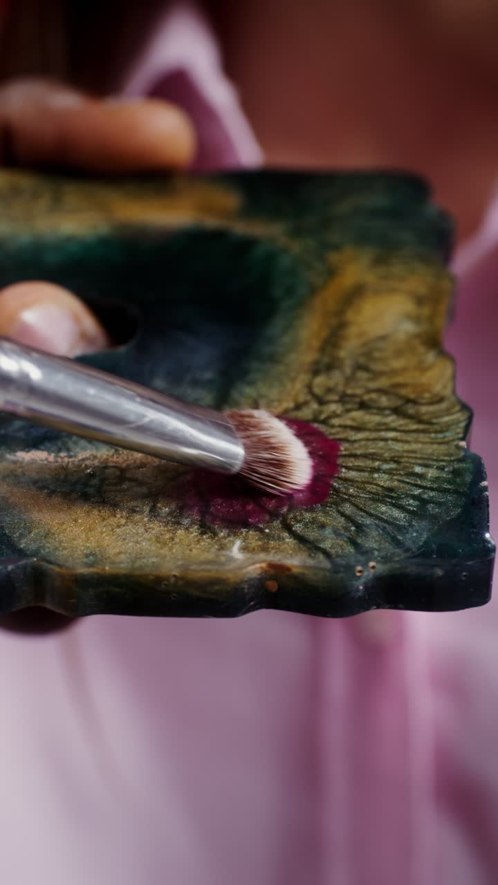 Applying makeup with a brush on a palette