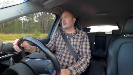 a tired man hydrates with a bottle of water and rubs his face before a long drive