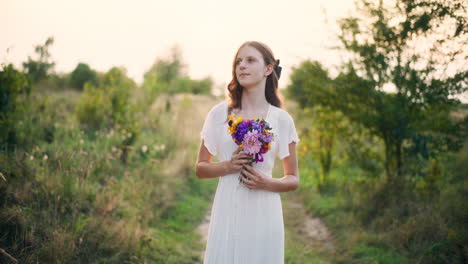 thoughtful girl holding bouquet at sunset portrait