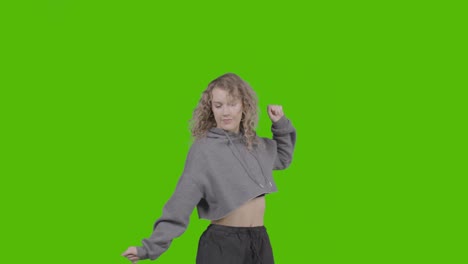 studio shot of young woman having fun dancing against green screen 9