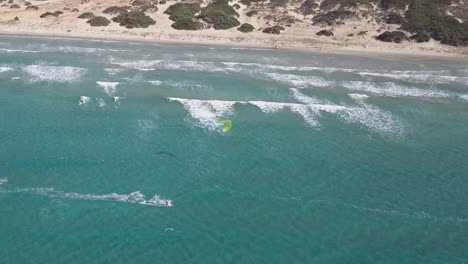 vista aérea: el surfista solitario disfruta de la soledad frente a una playa de arena clara