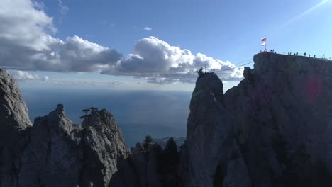 a breathtaking view from a mountain peak with a flag and people on a rope bridge