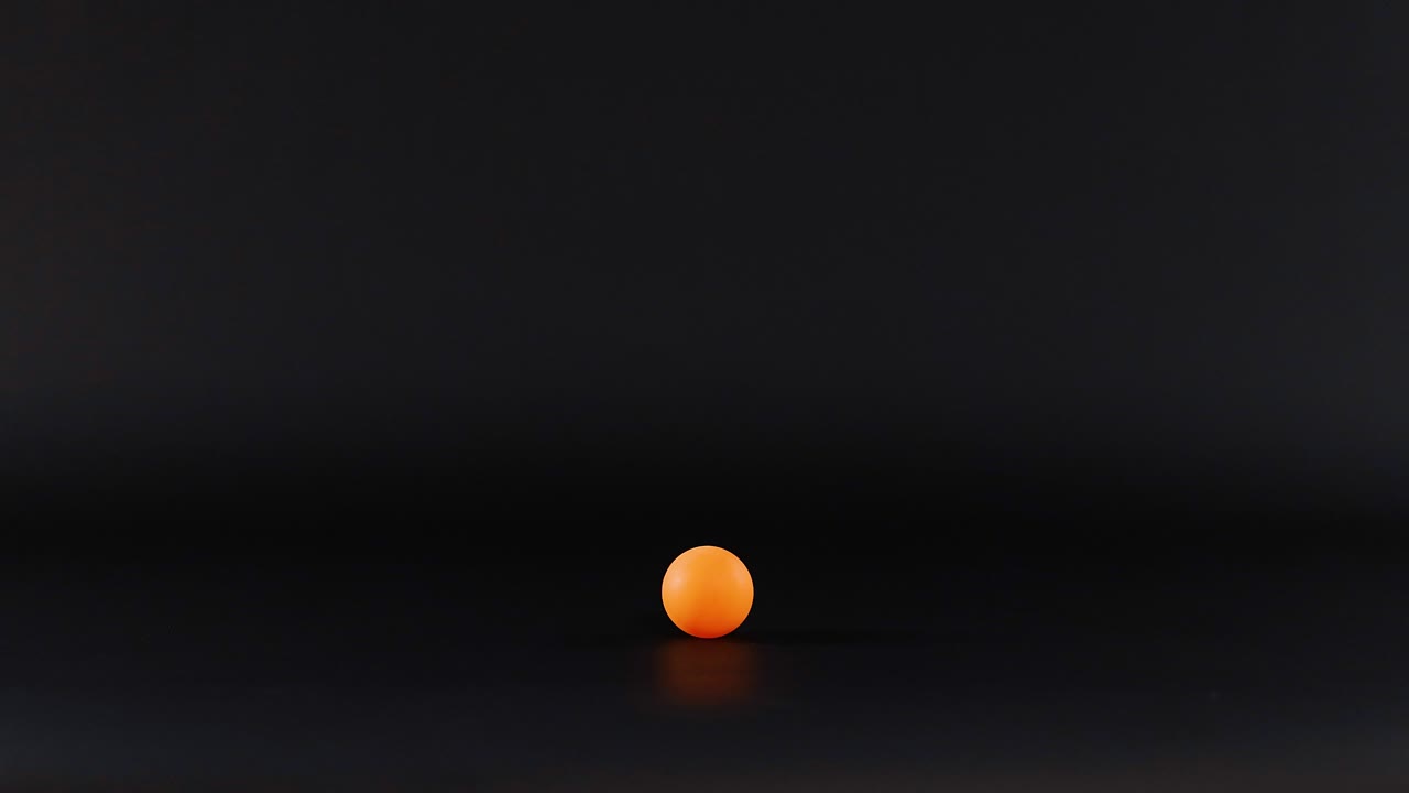 la bola naranja se mueve a través de una superficie oscura