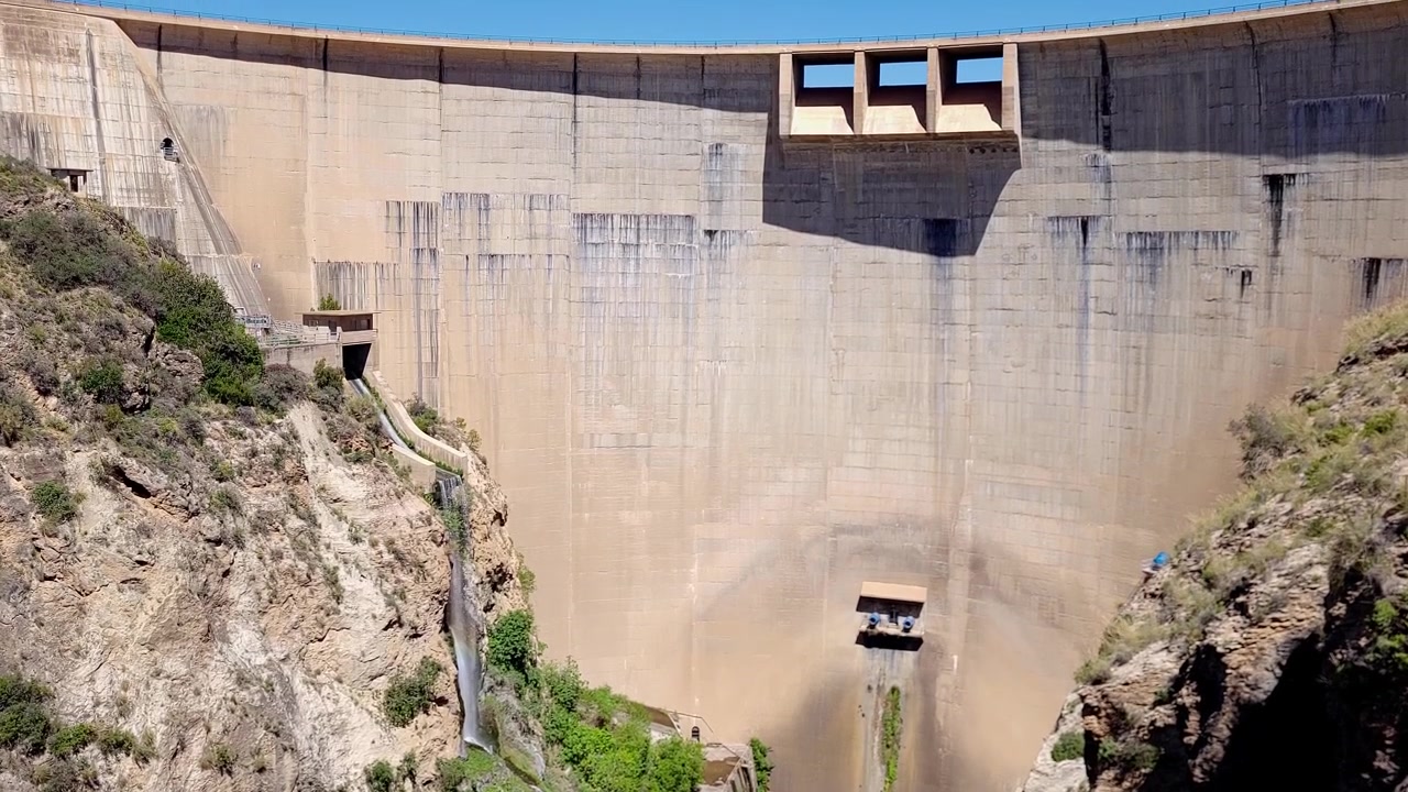 Diga a volta e bacino idrico. Vista panoramica dell'infrastruttura per l'immagazzinamento dell'acqua. Ingegneria e infrastrutture. Diga di Béznar. Spagna