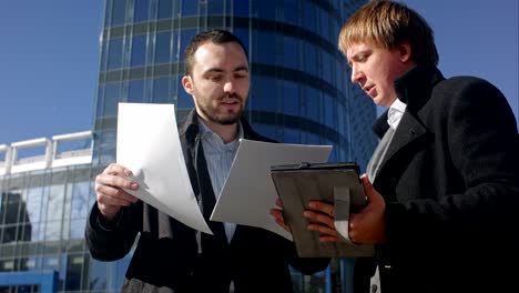 two young businessmen discussing document