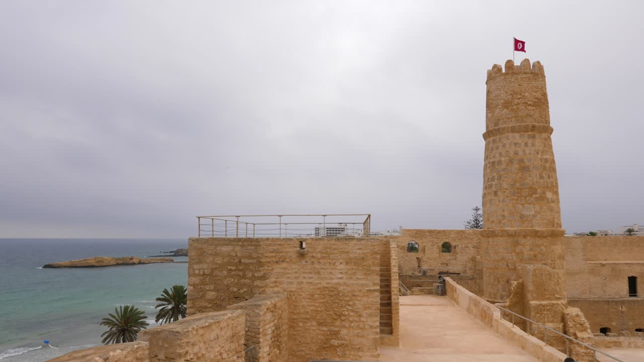la bandera nacional de túnez ondeando en el viento en la parte superior de la fortaleza protectora de ribat, monastir