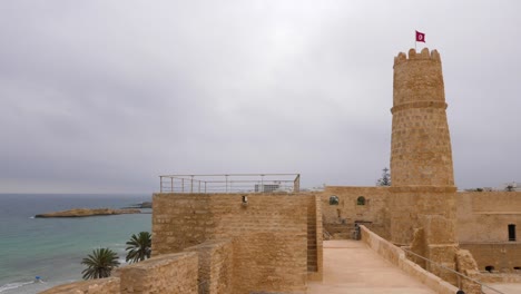 national flag tunisia waving on wind on top protective fortress ribat, monastir