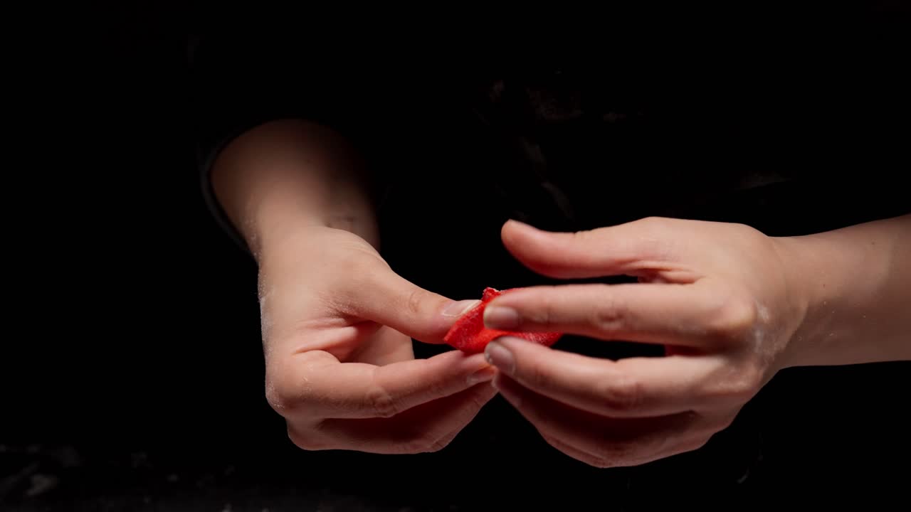 Close-up of Hands Folding Red Dumpling Dough