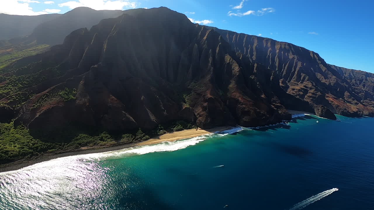 Vista aerea di costa blu e onde che si infrangono lungo le dolci colline a Kauai, Hawaii
