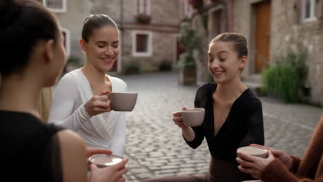 ballerinas drinking coffee in courtyard