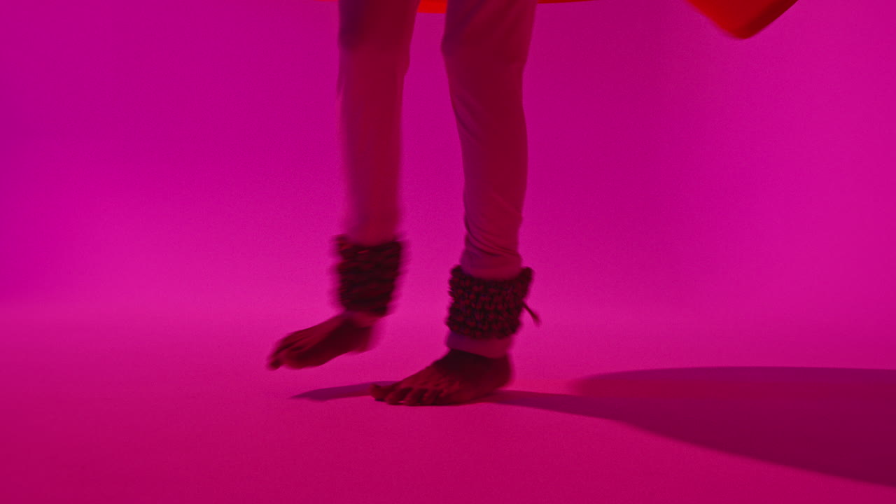 близко к ногам и колоколом женщины-танцовщицы катхака, исполняющей танец в традиционной индийской одежде на фиолетовом фоне 1