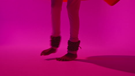 Close-Up-On-Feet-And-Bells-Of-Female-Kathak-Dancer-Performing-Dance-Wearing-Traditional-Indian-Dress-Against-Purple-Background-1