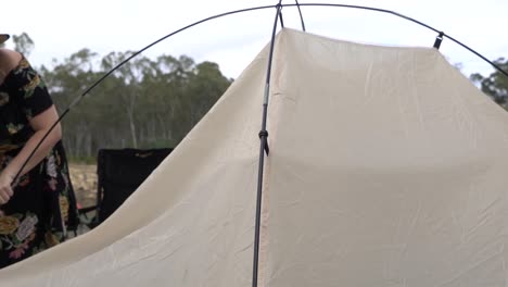 Outdoor-nature-blonde-woman-packing-up-tent-camping-outback