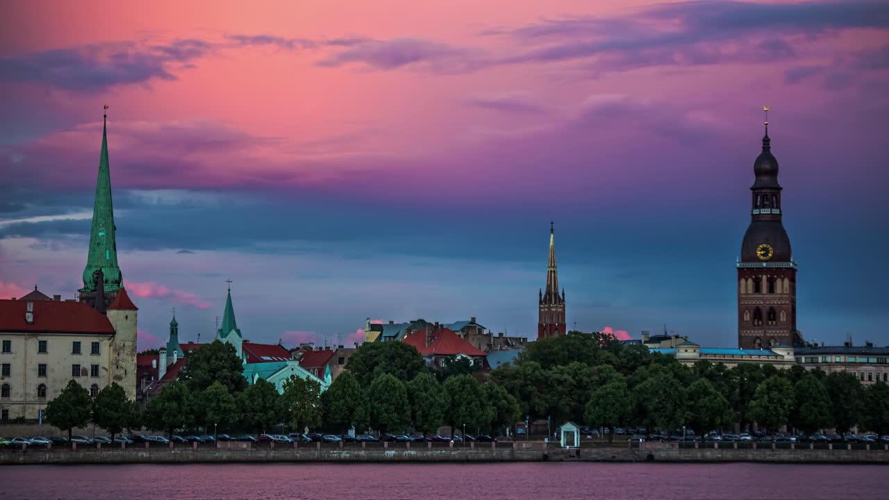 vista de catedrales sobre el río daugava en riga, lapso de tiempo de cielo rosa, puesta de sol