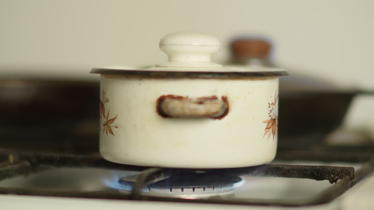 la sartén está en la estufa con el gas encendido, la cámara en movimiento