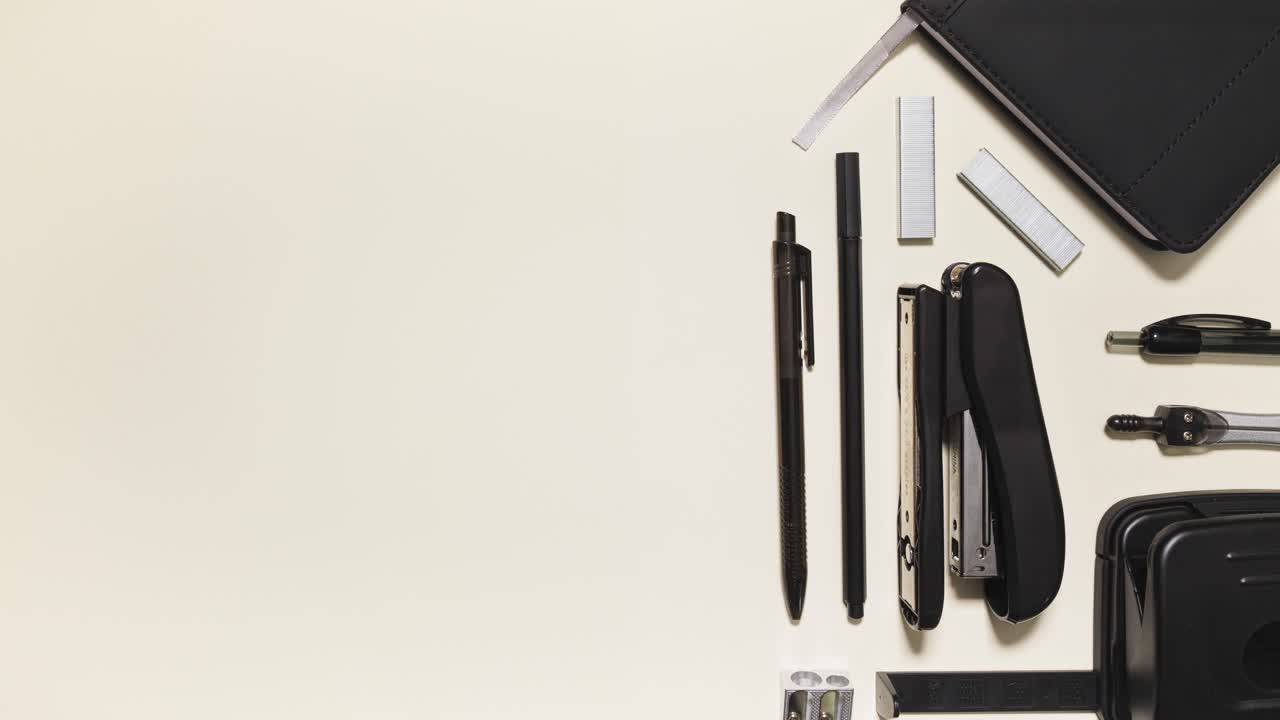 Stop motion of monochrome office supplies sliding in and arranging, leaving big negative space