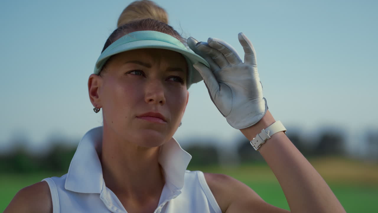 미소 짓는 골프 여자 얼굴 초록색 코스 자연. 여자는 여름  ⁇ 빛을 즐긴다.