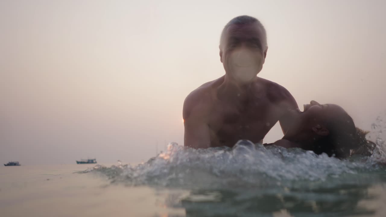 Couple Embracing in the Ocean at Sunset