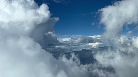impresionante vista aérea desde una cabina de jet volando a través de nubes cumulus durante el descenso al aeropuerto de sevilla, españa