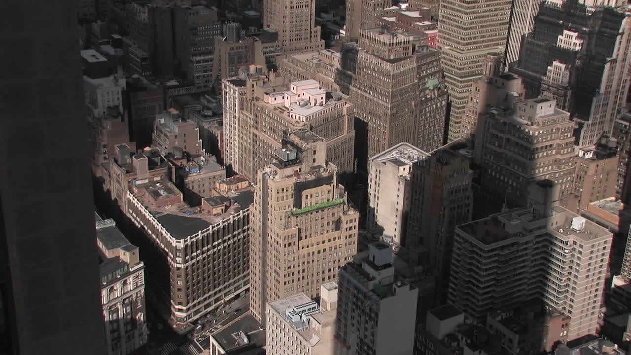 엠파이어 스테이트 빌딩의 그림자가 아래에 있는 여러 개의 작은 건물에 드리워져 있습니다.