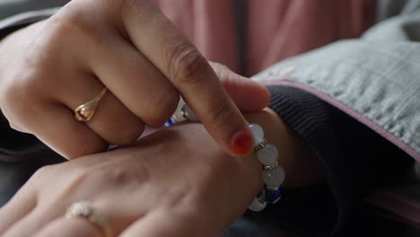 una mujer se pone un brazalete con un amuleto del mal ojo.