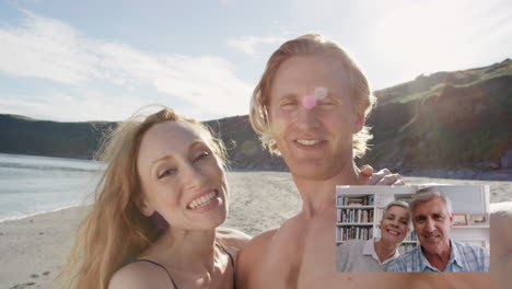 Pareja-De-Viajes-Chateando-Por-Video-Con-Padres-Ancianos-En-Casa-Compartiendo-Vacaciones-De-Luna-De-Miel-En-La-Playa-Sonriendo-Y-Saludando