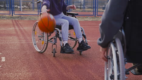 joven discapacitada rebotando la pelota y lanzándola a su amiga y al aro de baloncesto