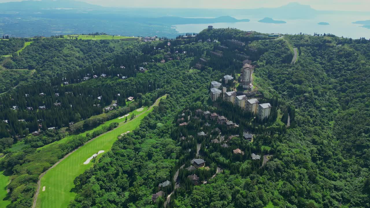 A pull-out aerial of The Woodlands Tagaytay Highlands revealing pine trees, hillside homes, and forested terrain in Batangas, Philippines
