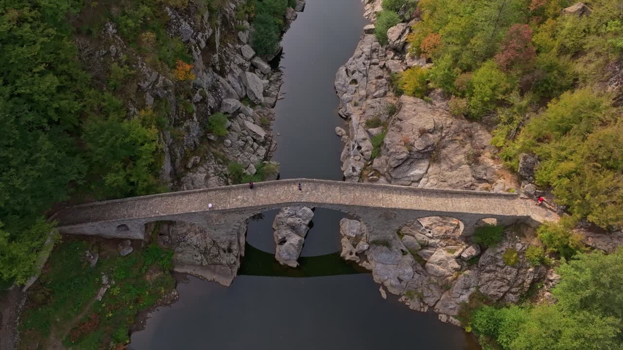 Kallioiset rinteet ja syyspuut ympäröivät ikonista Paholaisen siltaa, Bulgaria