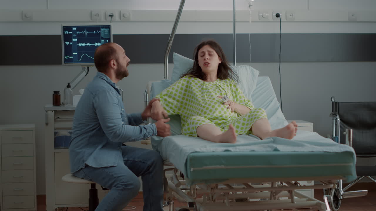 Těhotná žena kavkazského typu má bolesti způsobené kontrakcemi