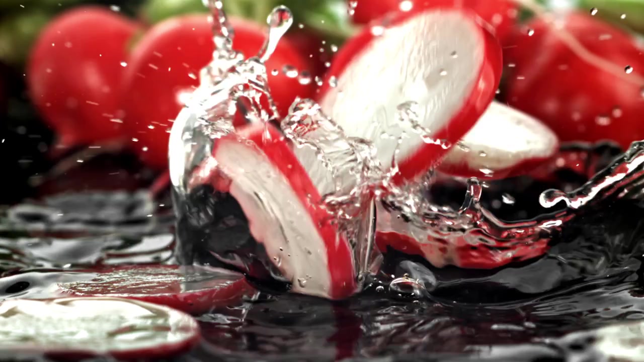 Rallentatore di ravanelli affettati che cadono nell'acqua con schizzi