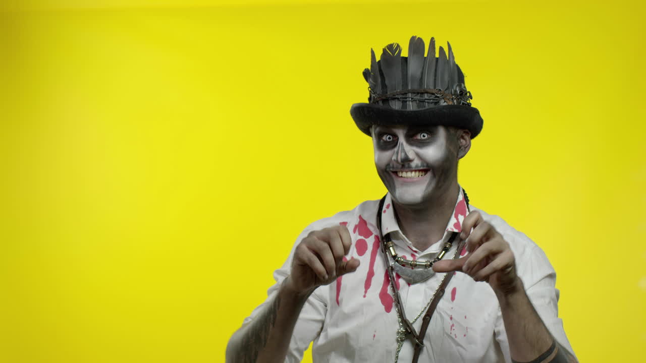 hombre siniestro con horrible maquillaje de esqueleto de halloween tratando de asustar, señalando a la izquierda