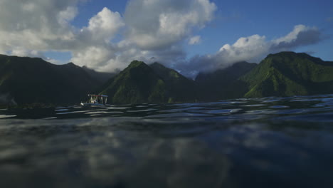 en el agua vista de botes de apoyo para surfistas y montañas del valle de tahití en teahupoo