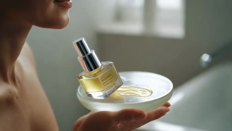 woman applying skincare or perfume in a bathroom