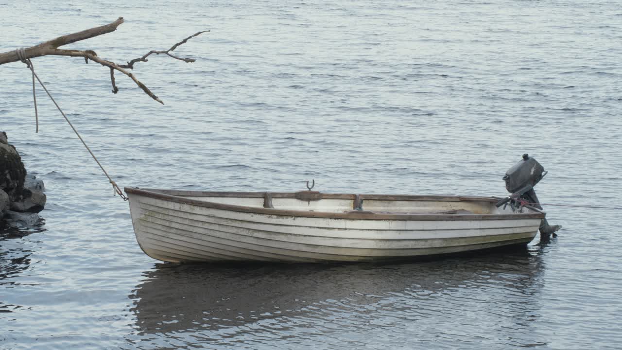 Fiberglass lake boat moored off shoreline
